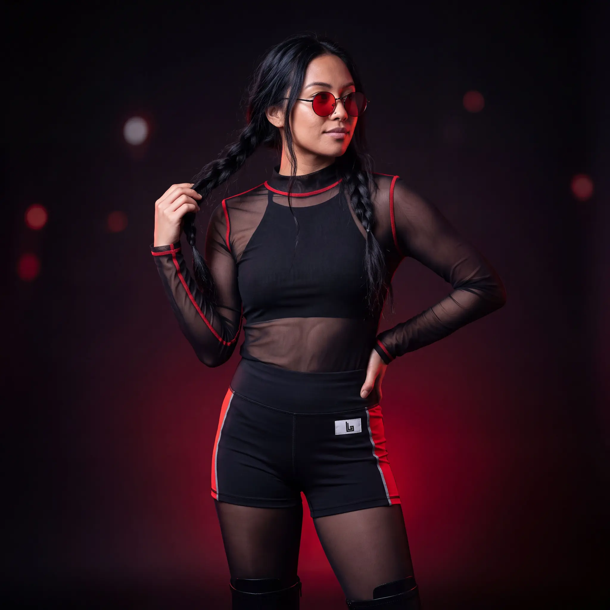 Custom festival and rave wear by Lethletic: model in a black and red rave set with mesh top
